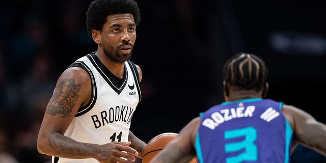 Kyrie Irving of the Brooklyn Nets brings the ball up court against the Charlotte Hornets at Spectrum Center on March 8, 2022, in Charlotte, North Carolina.