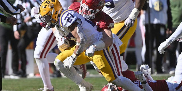 LSU running back Josh Williams (27) is tackled by Arkansas linebacker Bumper Pool (10) during the first half of a game Saturday, Nov. 12, 2022, in Fayetteville, Ark.