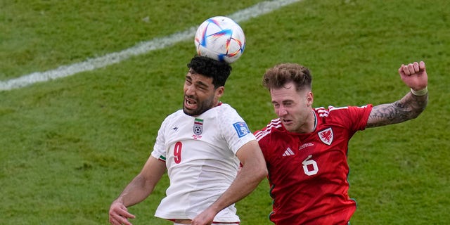 Iran's Mehdi Taremi, left, duels for the ball with Wales' Joe Rodon during the World Cup Group B match at Ahmad bin Ali Stadium in Al Rayyan, Qatar, Nov. 25, 2022.