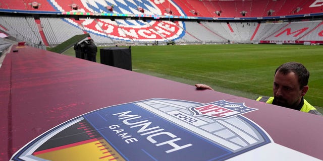 Workers prepare a sign inside the FC Bayern München soccer stadium Allianz Arena in Munich, Germany, Wednesday, Nov. 9, 2022. The Tampa Bay Buccaneers are set to play the Seattle Seahawks in an NFL game at the Allianz Arena in Munich on Sunday.