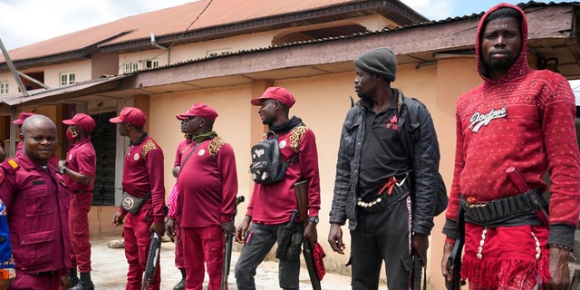 Vigilante stand guard outside the St. Louis Catholic hospital in the town of Owo, Nigeria, Monday, June 6, 2022.