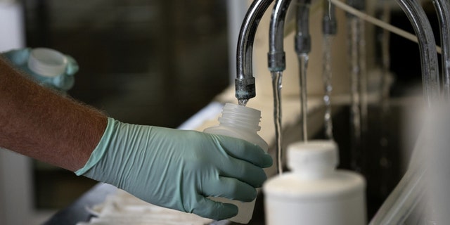 A geologist collects samples of treated Lake Michigan water in a laboratory in Wilmette, Illinois, on July 3, 2021.