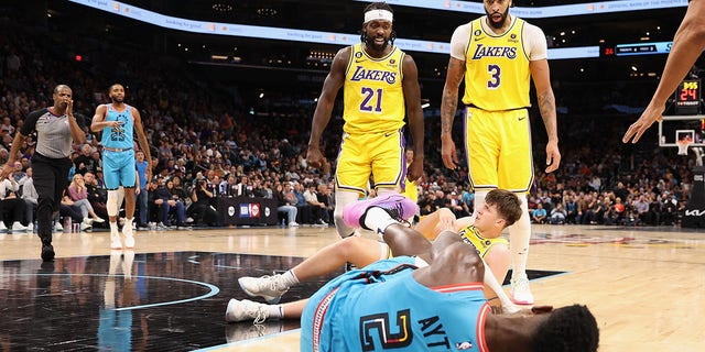 Patrick Beverley #21 of the Los Angeles Lakers reacts after pushing Deandre Ayton #22 of the Phoenix Suns to the ground, alongside Anthony Davis #3 and Austin Reaves #15, during the second half of the NBA game at Footprint Center on November 22, 2022 in Phoenix, Arizona.