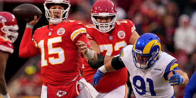 Kansas City Chiefs quarterback Patrick Mahomes (15) throws a pass as he is pressured by Los Angeles Rams defensive tackle Greg Gaines (91) during the first half of an NFL football game Sunday, Nov. 27, 2022, in Kansas City, Mo.