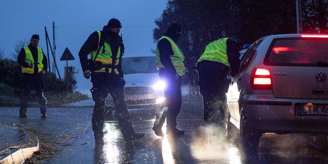 Police officers check documents at a checkpoint near the scene of a blast in Przewodow, Poland, Wednesday, Nov. 16, 2022.