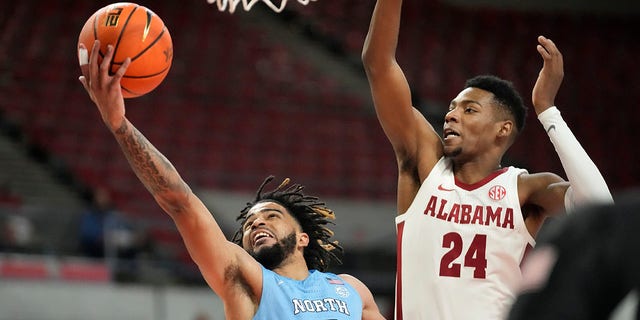 North Carolina guard R.J. Davis, #4, goes to the basket as Alabama forward Brandon Miller, #24, defends during the first half of an NCAA college basketball game in the Phil Knight Invitational on Sunday, Nov. 27, 2022, in Portland, Oregon.