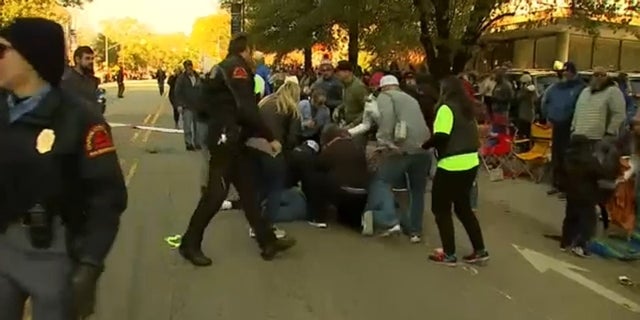 People and first responders attend to a girl who was hit by a truck during the Raleigh, North Carolina Christmas parade Saturday.