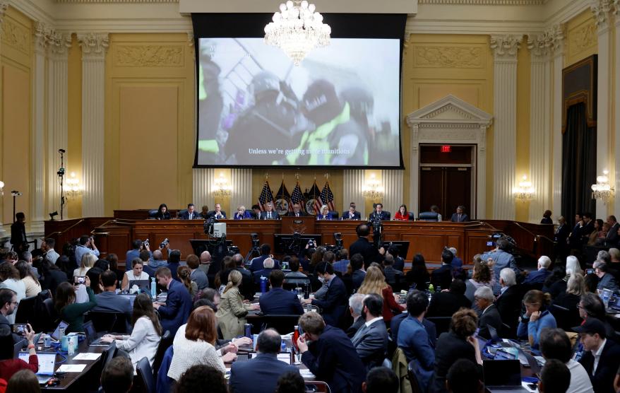 People look on at a screen showing footage of the Jan. 6 attack during the U.S. House Select Committee's public hearing on Capitol Hill in Washington, D.C.