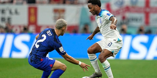 Sergino Dest of the United States and England's Raheem Sterling battle for possession during their match in Al Khor , Qatar, Friday, Nov. 25, 2022.