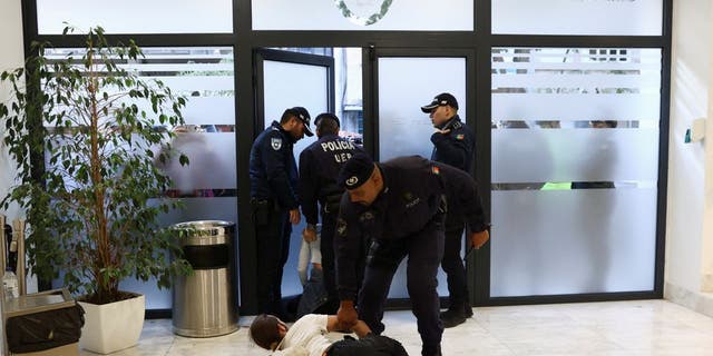 Police officers remove a protester for climate change and against the use of fossil fuels from a private event where, according to the local media, Antonio Costa Silva, Minister of the Economy and Maritime Affairs of Portugal was participating in Lisbon, Portugal, November 12, 2022. 