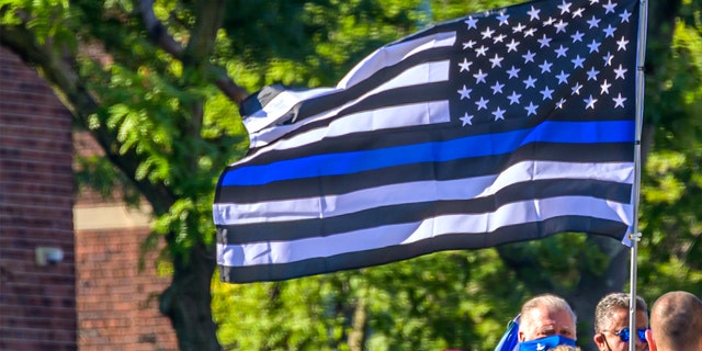 Protesters carryng a Blue Lives Matter flag 