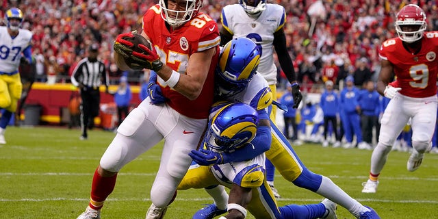 Kansas City Chiefs tight end Travis Kelce (87) scores on a 39-yard touchdown reception ahead of Los Angeles Rams safety Nick Scott, lower right, and cornerback Jalen Ramsey during the first half of an NFL football game Sunday, Nov. 27, 2022, in Kansas City, Mo. 