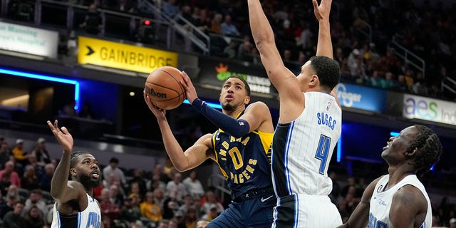 Indiana Pacers guard Tyrese Haliburton shoots around Orlando Magic guard Jalen Suggs in Indianapolis, Saturday, Nov. 19, 2022.