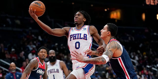 Philadelphia 76ers guard Tyrese Maxey, #0, shoots over Washington Wizards forward Kyle Kuzma in the second half of an NBA basketball game, Monday, Oct. 31, 2022, in Washington, D.C.