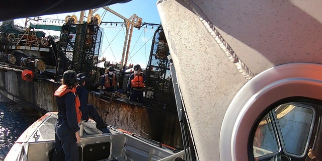 In this photo made available by the U.S. Coast Guard, guardsmen from the cutter James conduct a boarding of a fishing vessel in the eastern Pacific Ocean, on Aug. 6, 2022. During the 10-day patrol for illegal, unreported or unregulated fishing, three vessels steamed away. Another turned aggressively 90 degrees toward the James, forcing the American vessel to maneuver to avoid being rammed. (Petty Officer 3rd Class Hunter Schnabel/U.S. Coast Guard via AP)