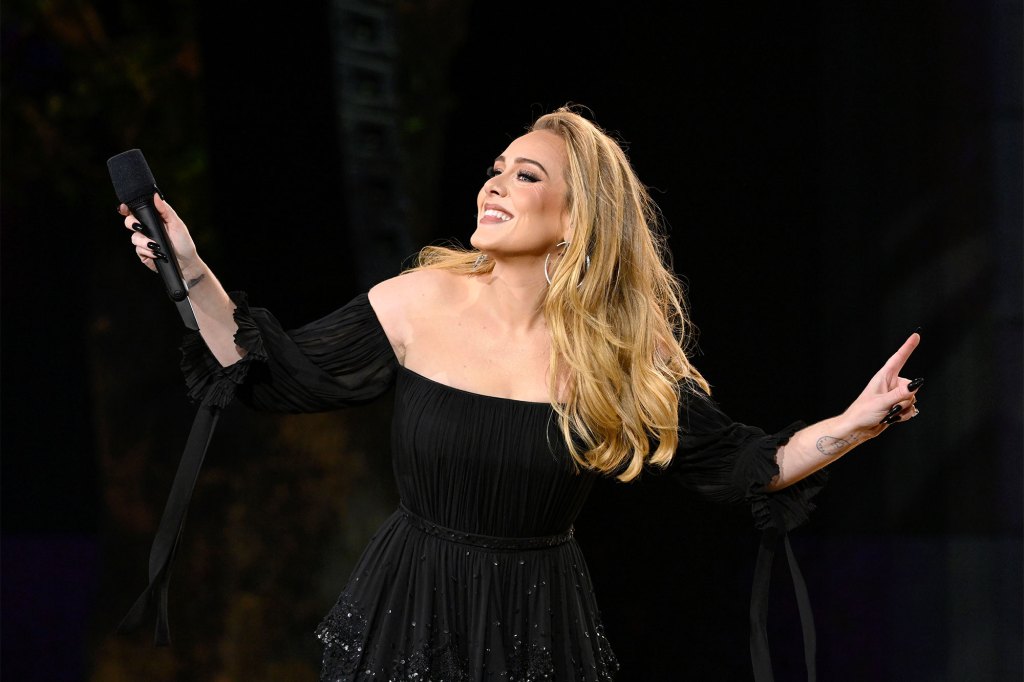 Adele wears a black dress as she performs