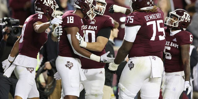 Donovan Green #18  celebrates his touchdown with Evan Stewart #1, Noah Thomas #9, and Kam Dewberry #75 of the Texas A&amp;M Aggies during the first half against the LSU Tigers at Kyle Field on November 26, 2022 in College Station, Texas. 