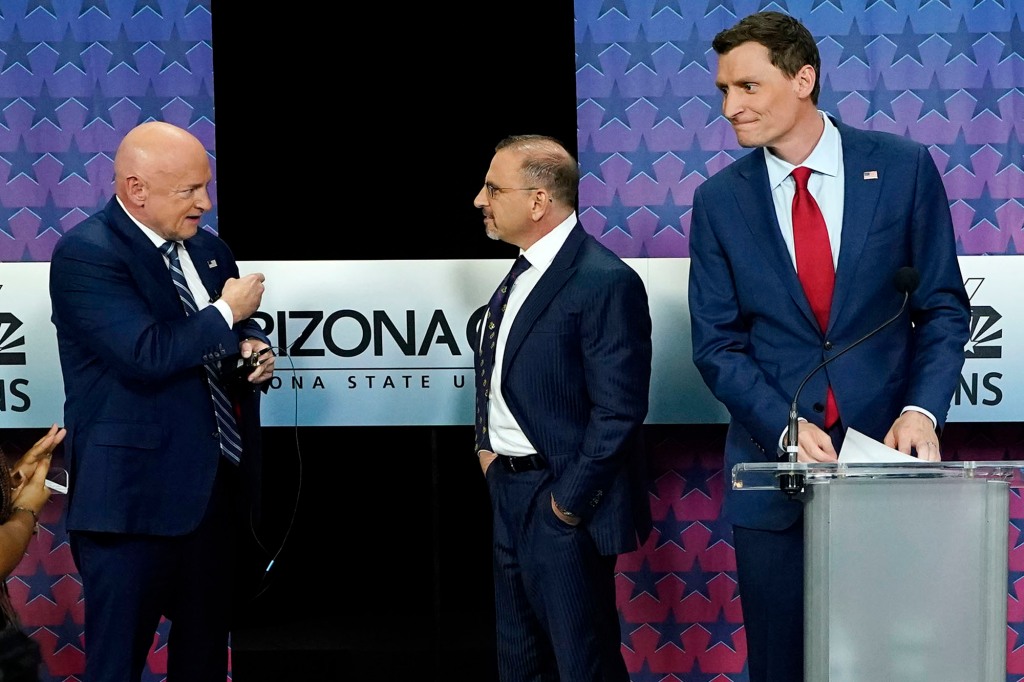 Arizona Democratic Sen. Mark Kelly, left, talks with Libertarian candidate Marc Victor, middle, and Republican candidate Blake Masters, right, prior to a televised debate in Phoenix, Thursday, Oct. 6.