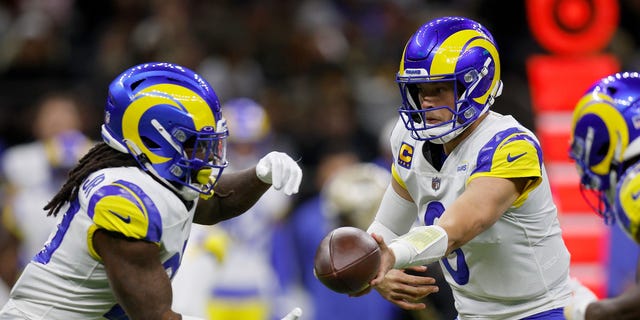 Matthew Stafford of the Los Angeles Rams, right, hands the ball off to Darrell Henderson Jr. during the first quarter against the New Orleans Saints at Caesars Superdome Nov. 20, 2022, in New Orleans.