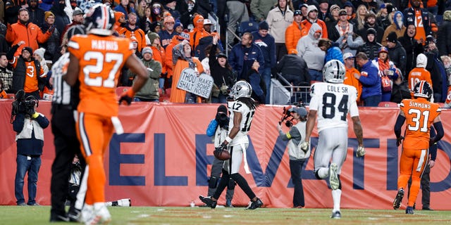 Davante Adams, #17 of the Las Vegas Raiders, completes a pass and runs for a touchdown to win in overtime during an NFL game between the Las Vegas Raiders and Denver Broncos at Empower Field At Mile High on Nov. 20, 2022 in Denver.