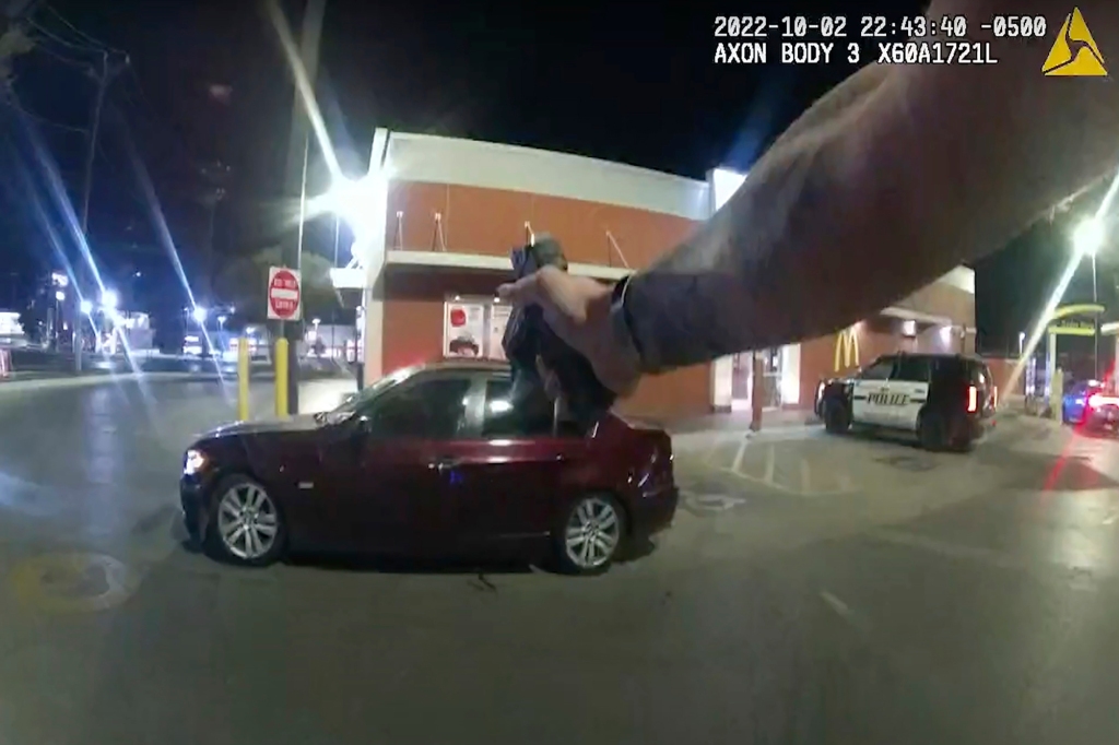 Erik Cantu drives away as San Antonio Police officer James Brennand shoots his pistol at the car in a fast food restaurant parking lot in San Antonio, Texas on Oct. 2, 2022.