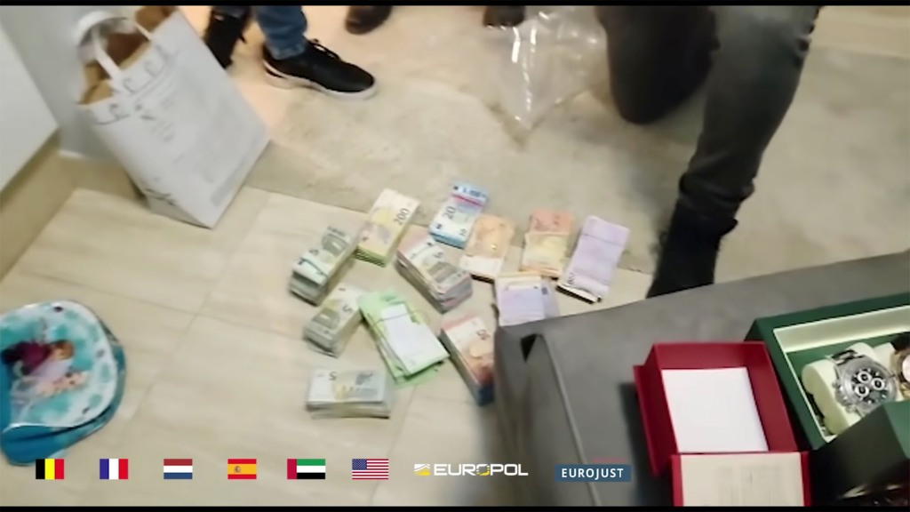Stacks of cash are seen during one of the raids that took place in Europe and the UAE earlier this month. 