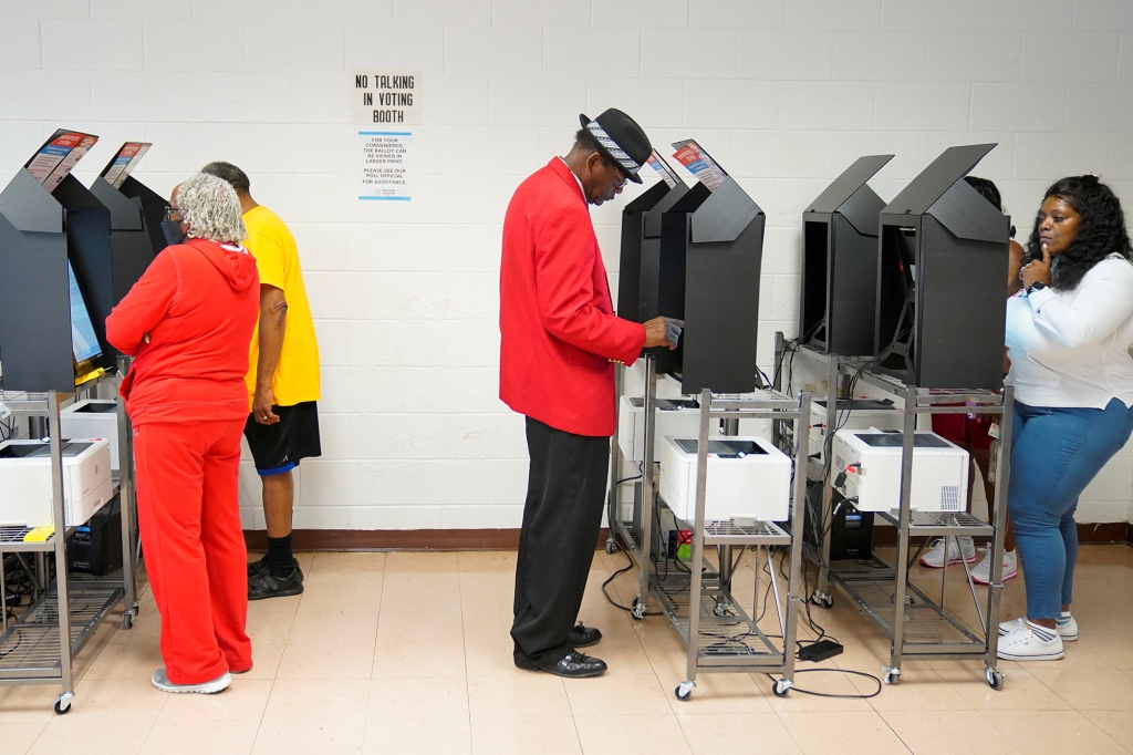 Georgia residents are pictured using machines to vote in the first round of the Senate election.
