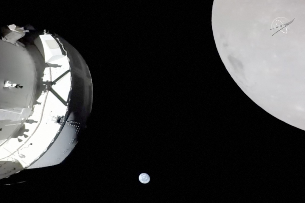 This handout image from NASA released on November 21, 2022, shows a view of the spacecraft, the Earth and the Moon captured by a camera on Orion's solar array wing.