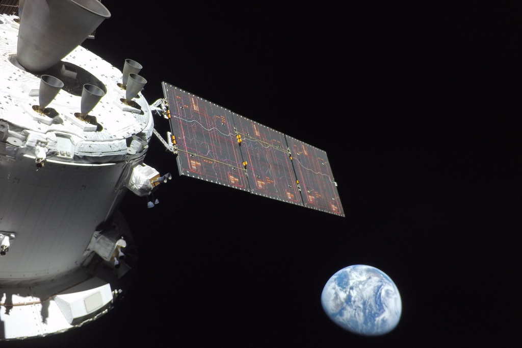 The Earth is seen as the flight control team used the cameras on the Orion's solar wings to do a thorough inspection of the spacecraft.