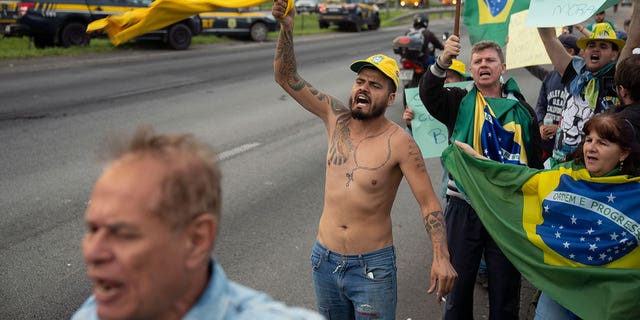 Supporters of Brazil's President Jair Bolsonaro protest his reelection loss on the side of the highway leading to Sao Paulo-Guarulhos International Airport, in Guarulhos, Brazil, Tuesday, Nov. 1, 2022. 