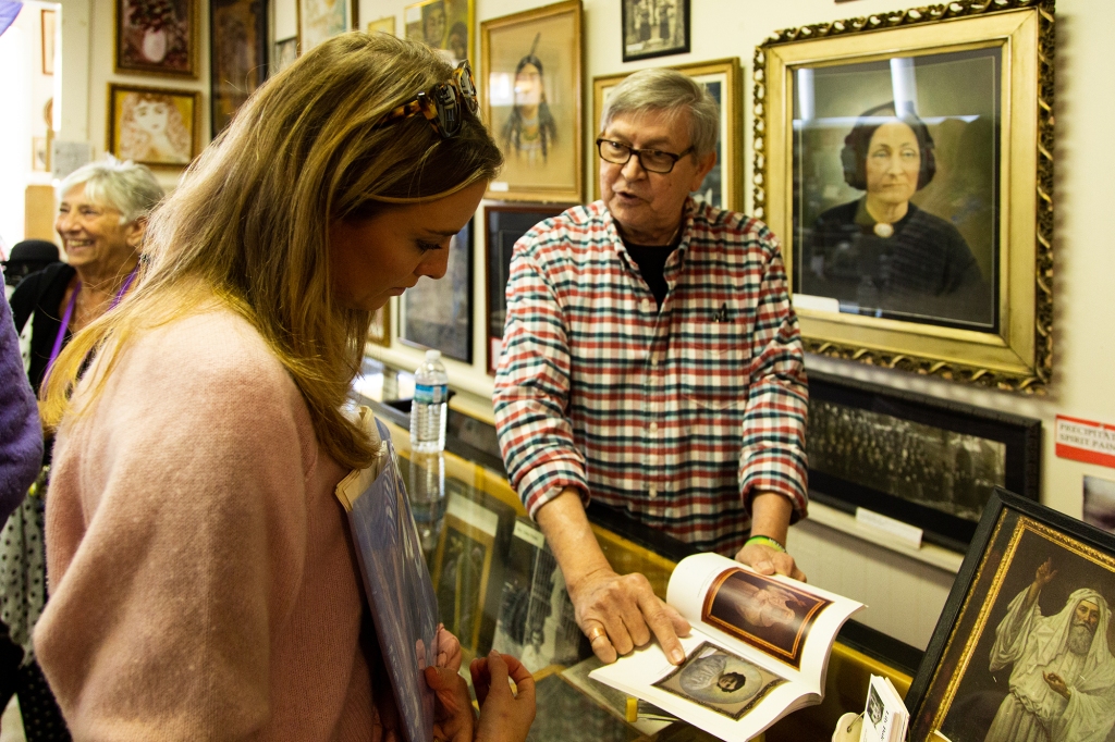 Ron Nagy, a former prison guard and Air Force veteran who moved to Lily Dale 21 years ago after a psychic medium relayed a message to him from his late grandfather, shows Schlott around Lily Dale Museum.