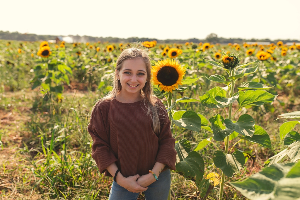 Shauna Rae standing in a field smiling. 