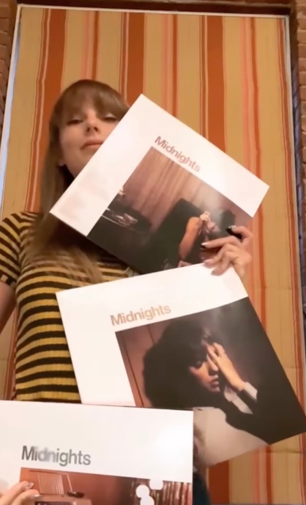 Taylor Swift holds copies of her new record. 