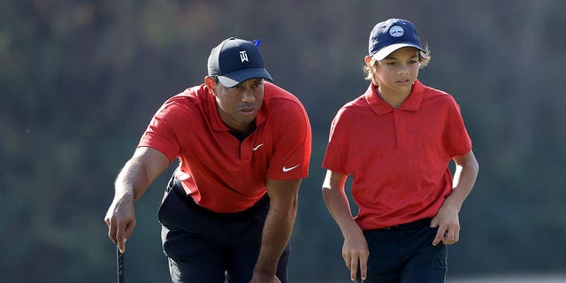 Tiger Woods and his son Charlie look over a shot on the 15th hole during the final round of the PNC Championship at the Ritz-Carlton Golf Club Grande Lakes in Orlando, Florida, on Dec. 19, 2021.