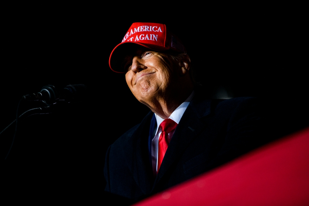 Former President Donald Trump smiles during huge rally in Iowa Thursday.