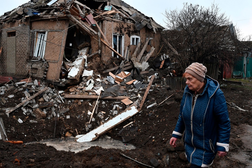 A woman walks past her house that was damaged in Russian shelling in Kramatorsk, Ukraine, Saturday, Nov. 19, 2022.