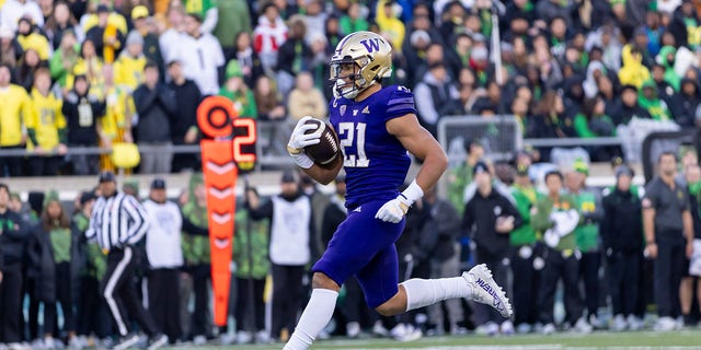 Running back Wayne Taulapapa #21 of the Washington Huskies runs fro a touchdown against the Oregon Ducks during the first half of the game at Autzen Stadium on November 12, 2022 in Eugene, Oregon.