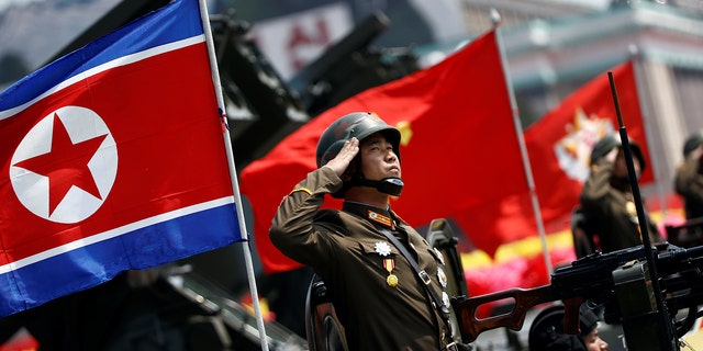 A soldier salutes from atop an armored vehicle as it drives past the stand with North Korean leader Kim Jong Un during a military parade marking the 105th birth anniversary of country's founding father Kim Il Sung.