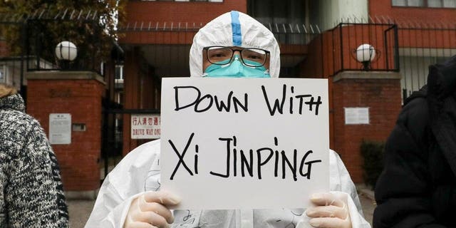 A person holds a banner during a protest in solidarity over the COVID-19 restrictions in mainland China, during a commemoration of the victims of a fire in Urumqi outside the Chinese consulate in Toronto November 29, 2022.