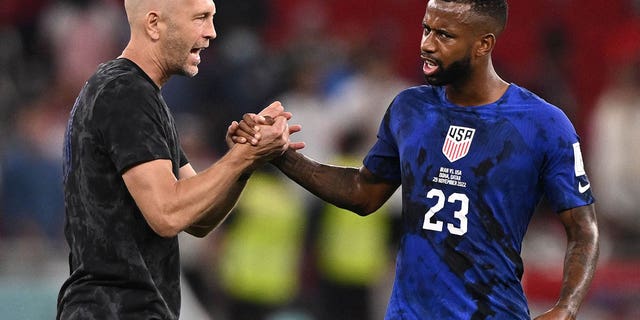 USA's coach #00 Gregg Berhalter (L) congratulates USA's midfielder #23 Kellyn Perry-Acosta at the end of the Qatar 2022 World Cup Group B football match between Iran and USA at the Al-Thumama Stadium in Doha on November 29, 2022. 