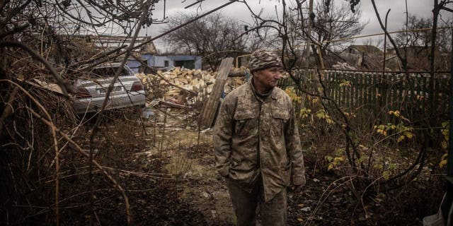 Anatoly Sikoza who buried the bodies stands Nov. 27, 2022, amid the rubble of a house where Russian forces killed seven men and one woman, hands bound, blindfolded and shot at close range.