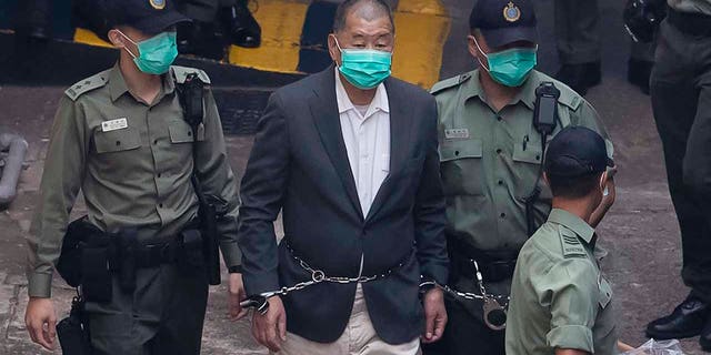 Hong Kong pro-democracy activist and media tycoon Jimmy Lai is escorted by Correctional Services officers to get on a prison van before appearing in a court in Hong Kong Dec. 12, 2020.