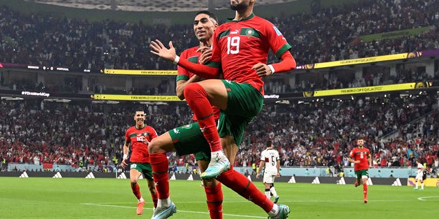 Morocco's forward #19 Youssef En-Nesyri celebrates with teammate Achraf Hakimi after scoring the opening goal against Portugal at the Al-Thumama Stadium in Doha on Dec. 10, 2022.