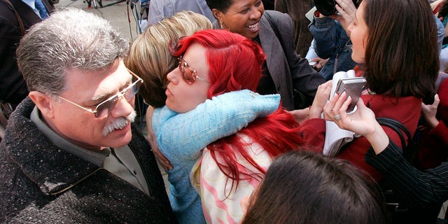 Juror Richelle Nice, center, hugs attorney Gloria Allred after speaking at a news conference after the formal sentencing of Scott Peterson in Redwood City, California, on March 16, 2005.