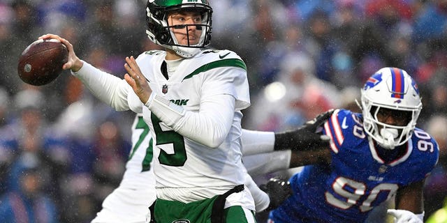 New York Jets quarterback Mike White (5) winds up to pass under pressure from Buffalo Bills defensive end Shaq Lawson (90) during the first half of an NFL football game, Sunday, Dec. 11, 2022, in Orchard Park, New York.