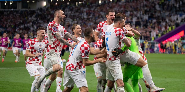 Croatian players celebrate with goalkeeper Dominik Livaković after he saves three penalty shots in a shootout during a FIFA World Cup Qatar 2022 round of 16 match between Japan and Croatia at Al Janoub Stadium Dec. 5, 2022, in Al Wakrah, Qatar. 