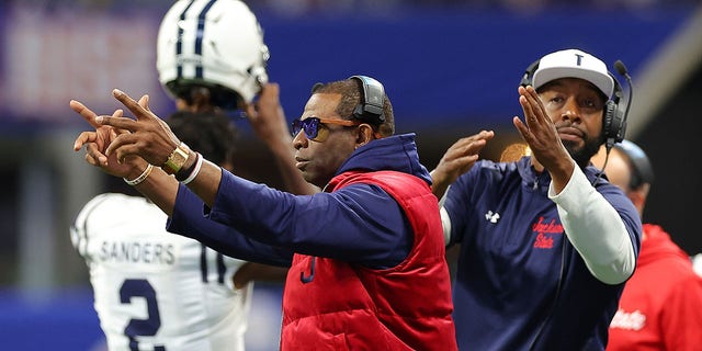 Head coach Deion Sanders and T.C. Taylor, the next head coach of the Jackson State Tigers, work the sideline against the North Carolina Central Eagles during the first half of the Cricket Celebration Bowl at Mercedes-Benz Stadium Dec. 17, 2022, in Atlanta.