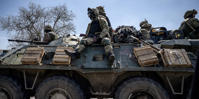 Ukrainian servicemen ride on an armored personnel carrier as they make their way along a highway on the outskirts of Kryvyi Rih. (Photo by ED JONES/AFP via Getty Images)