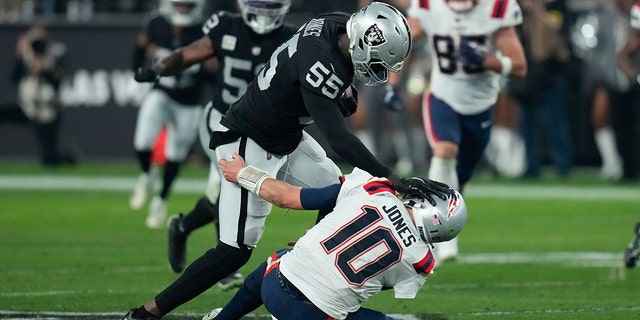 Las Vegas Raiders defensive end Chandler Jones, #55, breaks a tackle by New England Patriots quarterback Mac Jones, #10, to score a touchdown on an interception during the second half of an NFL football game between the New England Patriots and Las Vegas Raiders, Sunday, Dec. 18, 2022, in Las Vegas. 