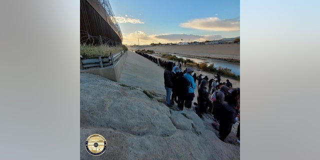 Migrants stand across the Rio Grande from El Paso, Texas. Thousands of migrants have illegally crossed into the city in recent days, prompting concerns from city officials. Texas Gov. 